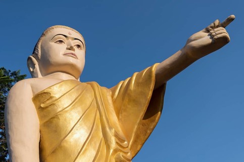 Buddha statue with extended arm and pointing finger