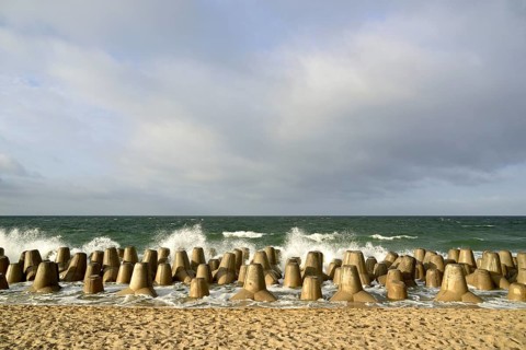 Waves break at concrete breakwaters