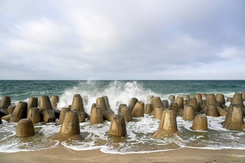 Waves break at concrete breakwaters