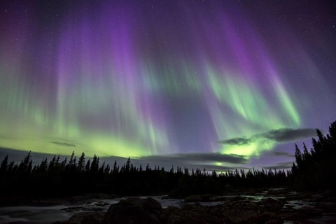Northern Lights or Aurora Borealis over the river Gamajahka or Kamajakka