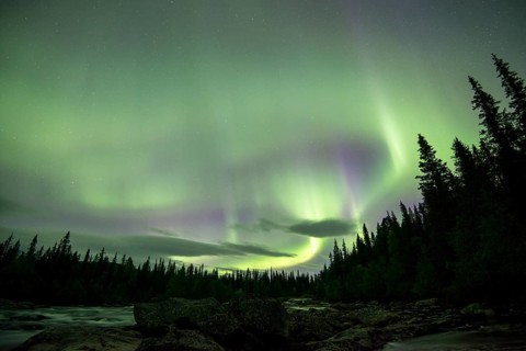 Northern Lights or Aurora Borealis over the river Gamajahka or Kamajakka