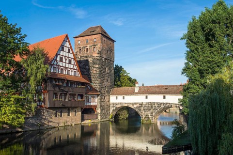 Old half-timbered house and water tower by the river Pegnitz
