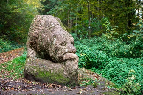 Wooden bear sculpture in front of Barenhohle in autumn near Pirmasens