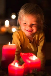 Toddler looking at advent candles at Christmas time
