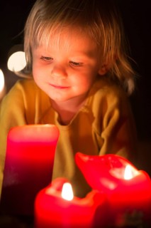 Toddler looking at advent candles at Christmas time