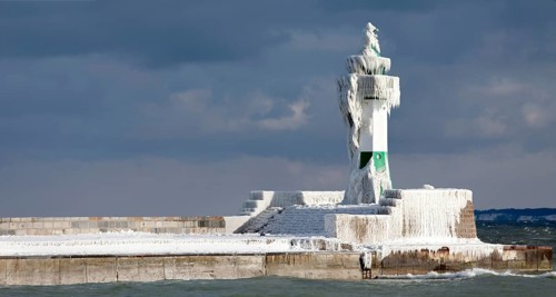 Icy lighthouse in harbour