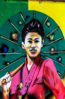 Painted image of a traditionally dressed woman on a house wall