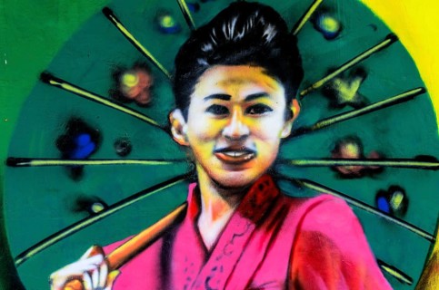 Painted image of a traditionally dressed woman on a house wall