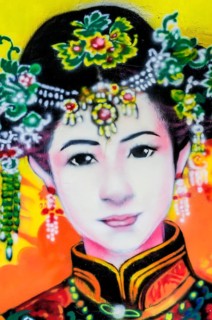 Painted image of a traditionally dressed woman on a house wall