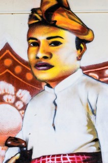 Painted image of a traditionally dressed man on a house wall