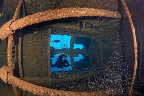Diver looking at the engine room of the shipwreck Giannis D.