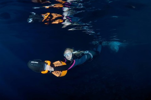 Freediver swimming with underwater scooter