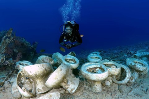 Diver looking at the plumbing on a shipwreck