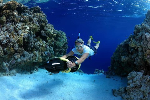 Freediver diving with underwater scooter