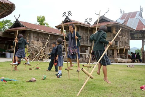 Tai Dam children walking on bamboo stilts