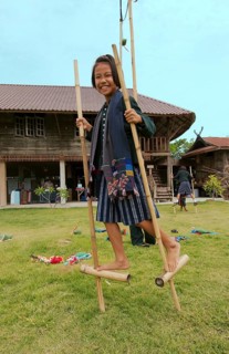 Tai Dam children walking on bamboo stilts