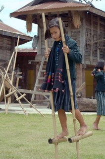 Tai Dam children walking on bamboo stilts