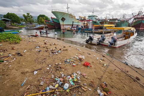 Fishing boats and beach with trash at the port of Ambon-Laha