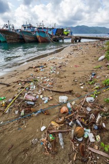 Fishing boats and beach with trash at the port of Ambon-Laha
