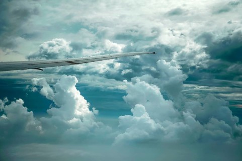 Dramatic cloud formations and the wing of a Boeing 777-300