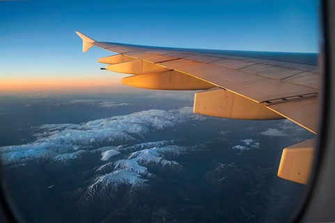 Wing of an Airbus A380-800 over snowy mountains