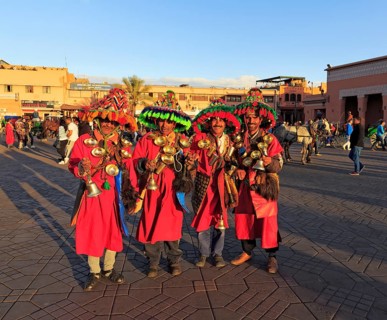 Guerrab or water carriers in traditional clothes with water bags and brass bowls on the jugglers square