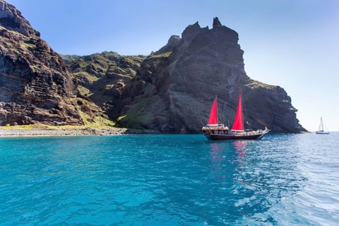 Sailing ship with red sails in a small bay near Los Gigantes