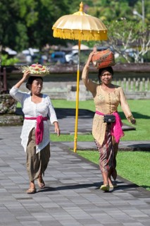 Women in traditional dress carrying basket with offerings on their heads