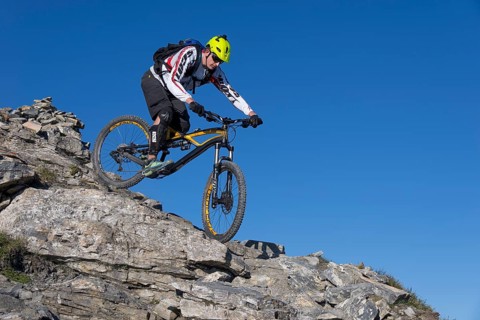 Freeride mountain biker riding over rocks