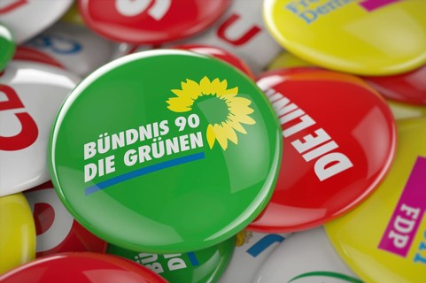 German political party Bundnis 90 Die Grunen button in front between other governing party buttons