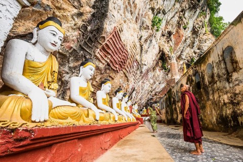 Monk looking at the seated Buddha statues