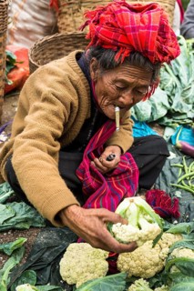 Smoking woman sells vegetables