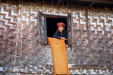 Old woman looking out of a lodge window