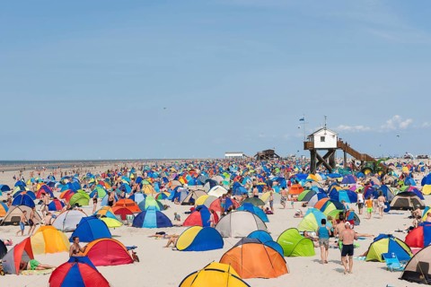Many bathers with beach tents on the beach