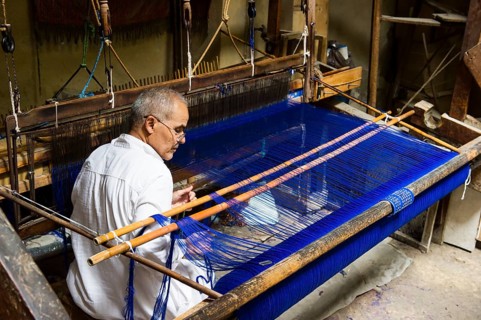 Man working on a loom in the historic centre