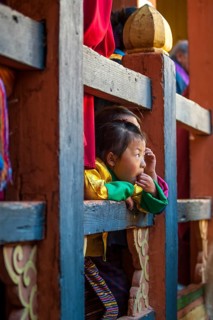 Children watching the happenings of a temple festival at Jakar Dzong