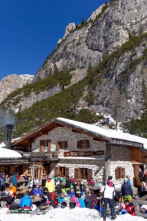 Rifugio Scotoni hut in winter with skiers