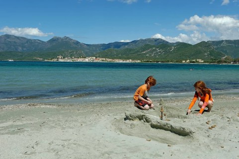 Children playing on the beach and bay of Saint Florent