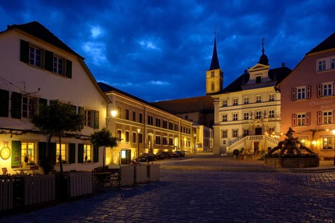Market place with parish church St. Veit and town hall at dusk
