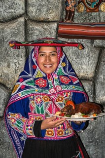 Woman serving roasted guinea pig Cuy chactado