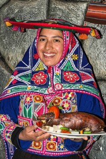 Woman serving roasted guinea pig Cuy chactado