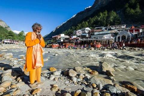 A devotee is praying at the waterfront of the young river Ganges