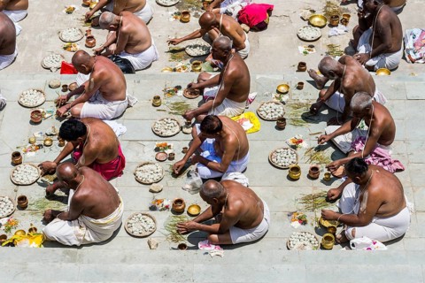 A group of male pilgrims is performing a pooja
