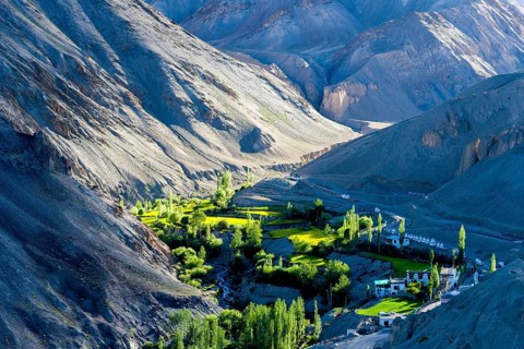 Barren landscape and green fields beside the village