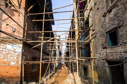 Damaged houses are stabilized by bamboo poles after the 2015 earthquake