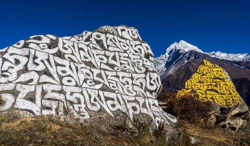 Big Mani stone inscribed with the tibetan mantra Om mani padme hum in the background mountain Kangtega