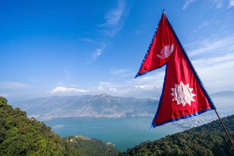 Nepali national flag waving high above the Phewa Lake and Pokhara