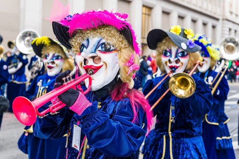 Members of the Gugge marching brass bands wearing fancy dresses and masks at the great procession of the Carnival of Basel