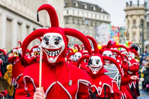 Members of the Gugge marching brass bands wearing fancy dresses and masks at the great procession at the Carnival of Basel