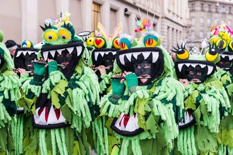 Members of the Gugge marching brass bands wearing fancy dresses and masks at the great procession at the Carnival of Basel